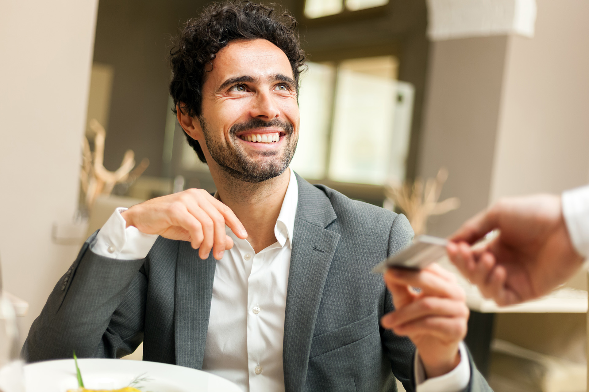 Gast bezahlt am Tisch mit Karte im Restaurant